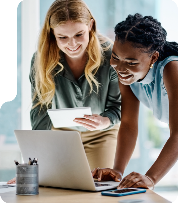 two women typing on laptop