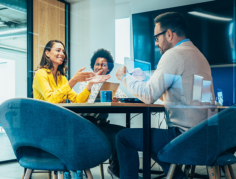 coworkers smiling and talking in office meeting